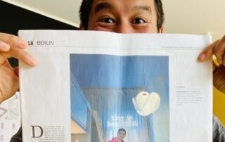 Architekt Van Bo Le-Mentzel hält einen Zeitungsartikel hoch