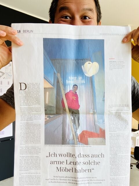Architekt Van Bo Le-Mentzel hält einen Zeitungsartikel hoch